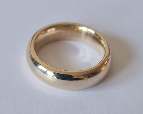 A 9ct solid yellow gold 4mm wide wedding band with a court profile and a polished finish.