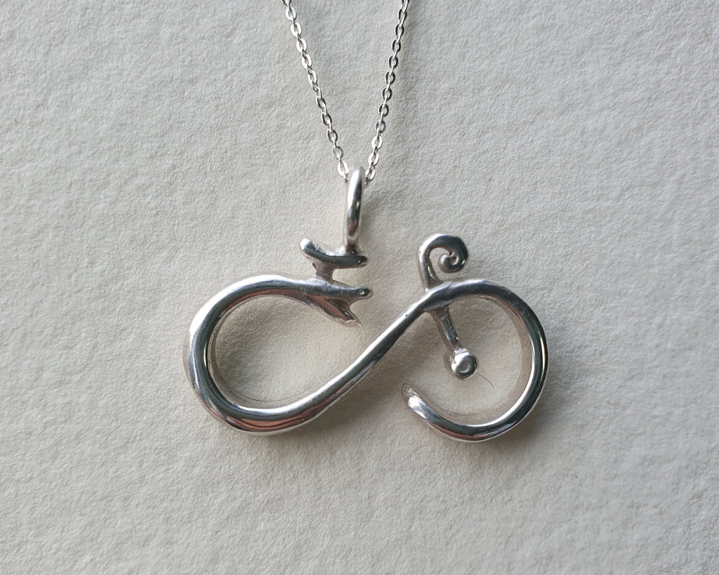 Silver necklace with a unique pendant on a light gray background