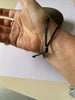 Sterling silver rugby ball link on braided bracelet.